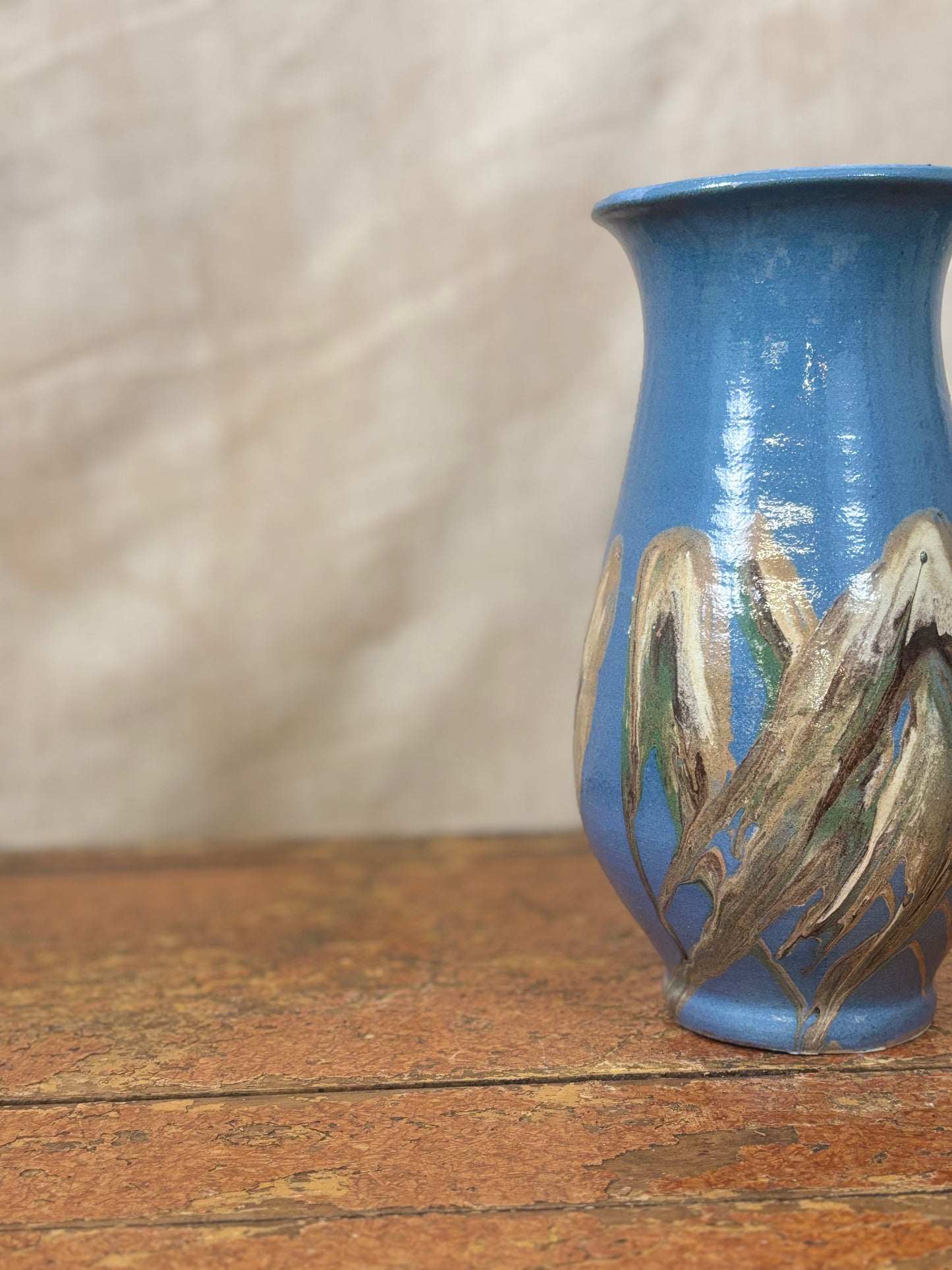 Blue ceramic vase with floral design on a wooden surface