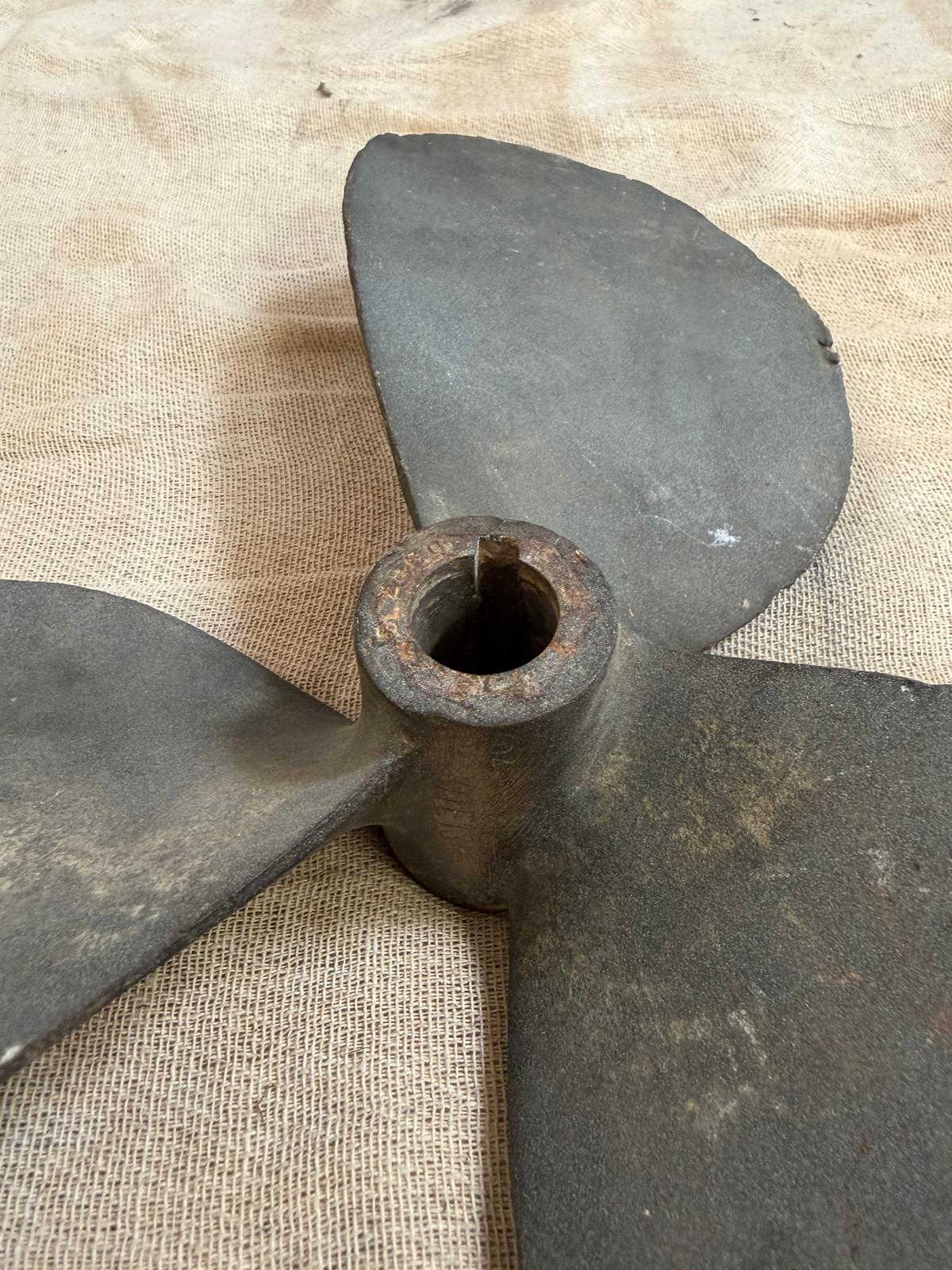 Rust-covered metal propeller on a burlap background