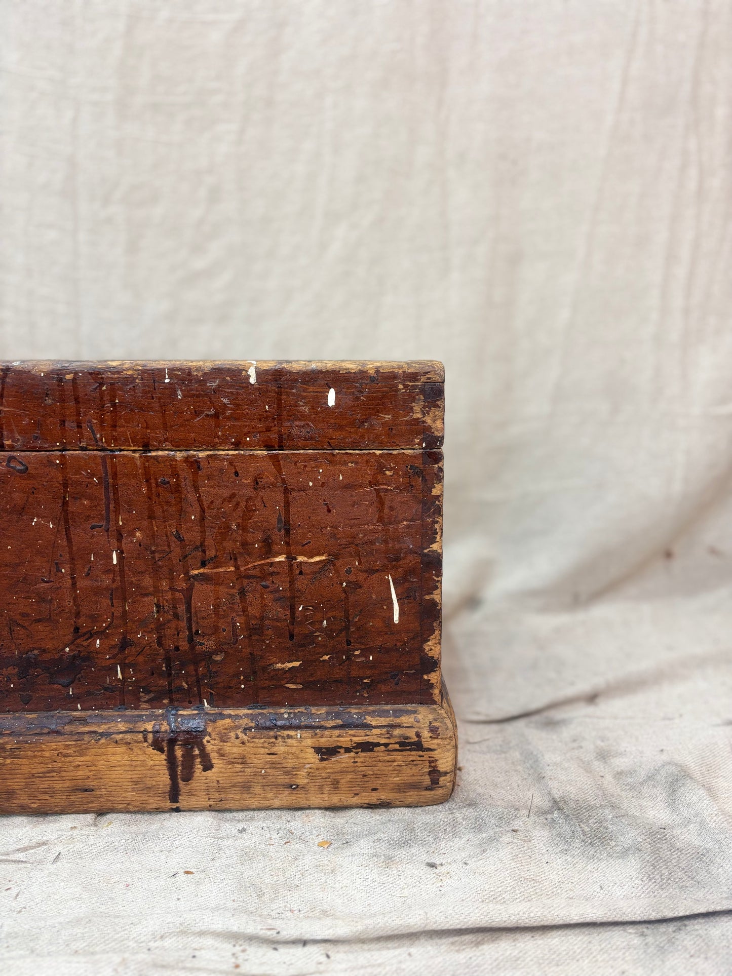 Vintage wooden box with a textured surface on a light fabric background