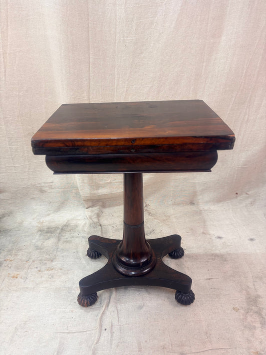 Antique rosewood fold-over games table shown closed on a cream background.