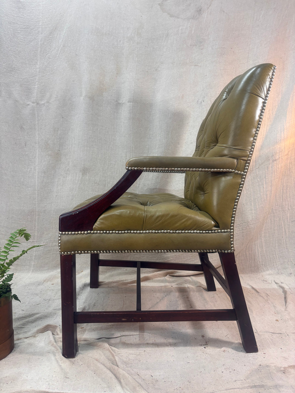 A Green Button Back Armchair