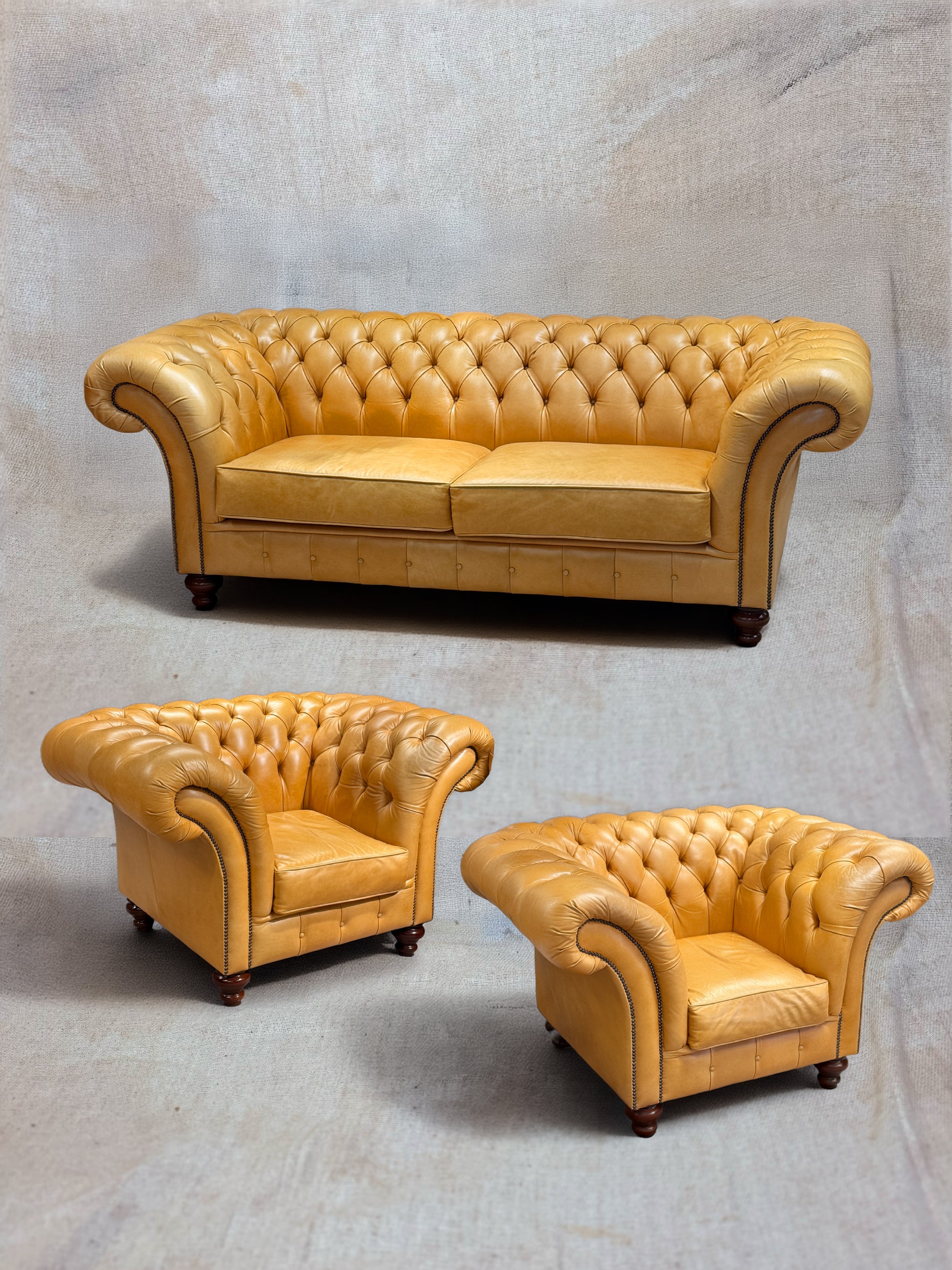 Set of three tan leather sofas on a gray background