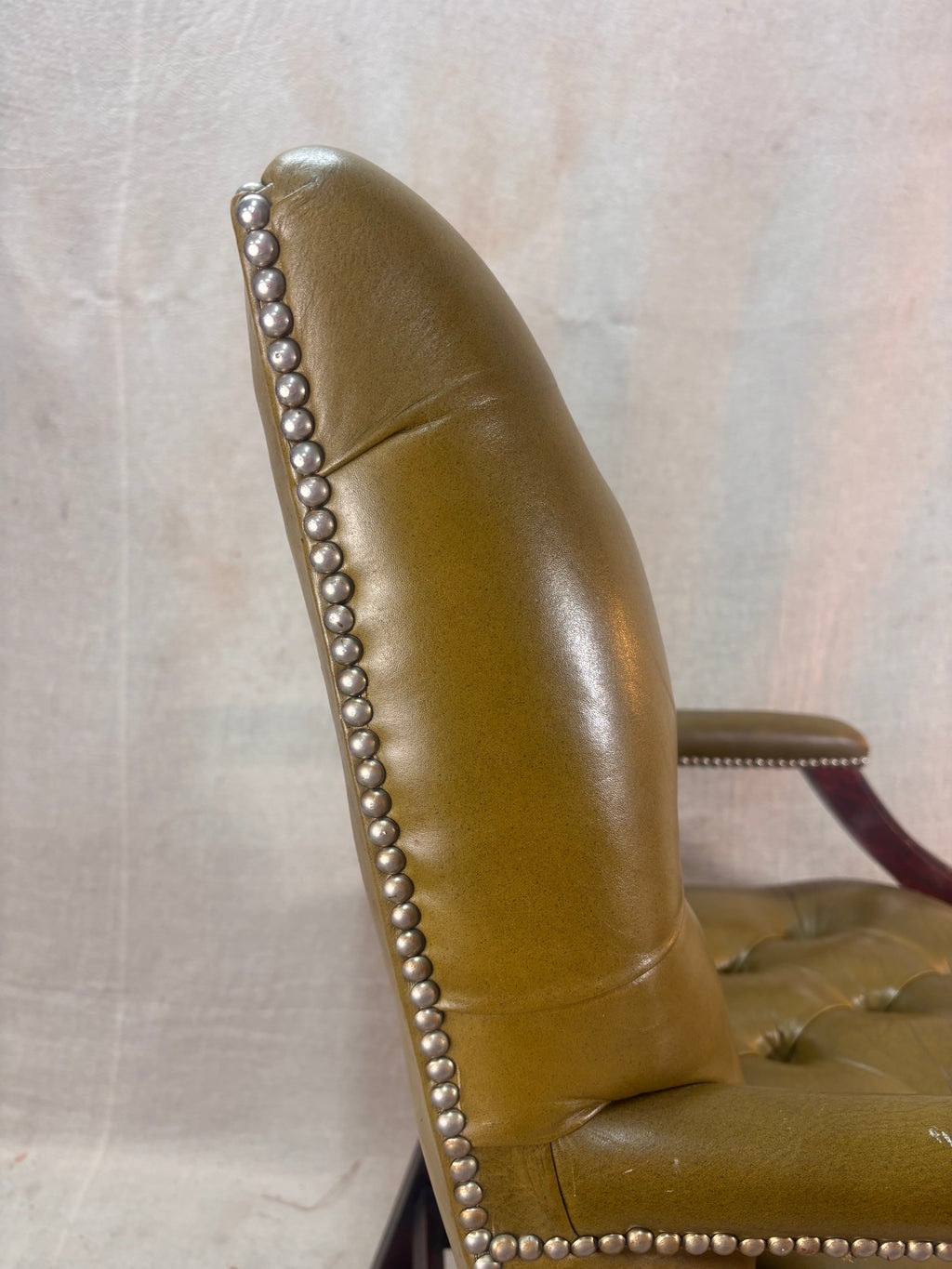 A Green Button Back Armchair