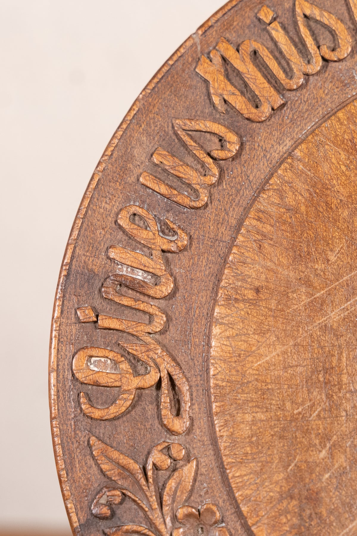 Vintage wooden bread board carved with “Give Us This Day Our Daily Bread” and a decorative floral and wheat motif around the rim.