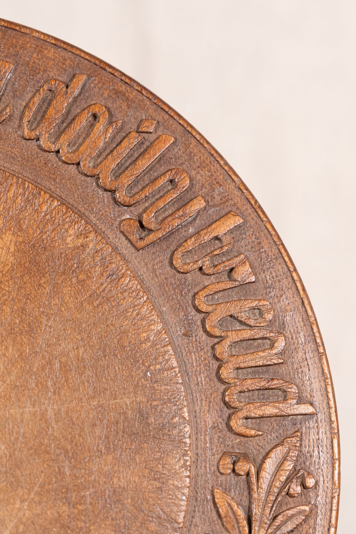 Vintage wooden bread board carved with “Give Us This Day Our Daily Bread” and a decorative floral and wheat motif around the rim.