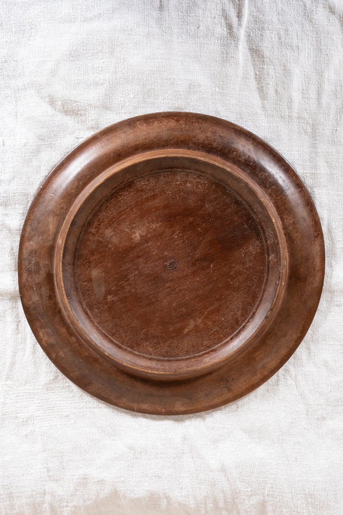 Vintage wooden bread board carved with “Give Us This Day Our Daily Bread” and a decorative floral and wheat motif around the rim.