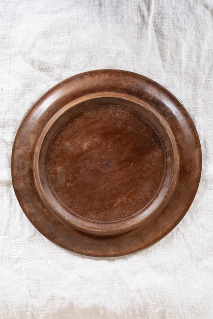 Vintage wooden bread board carved with “Give Us This Day Our Daily Bread” and a decorative floral and wheat motif around the rim.