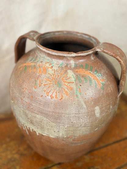 Terracotta vase with decorative patterns on a wooden surface