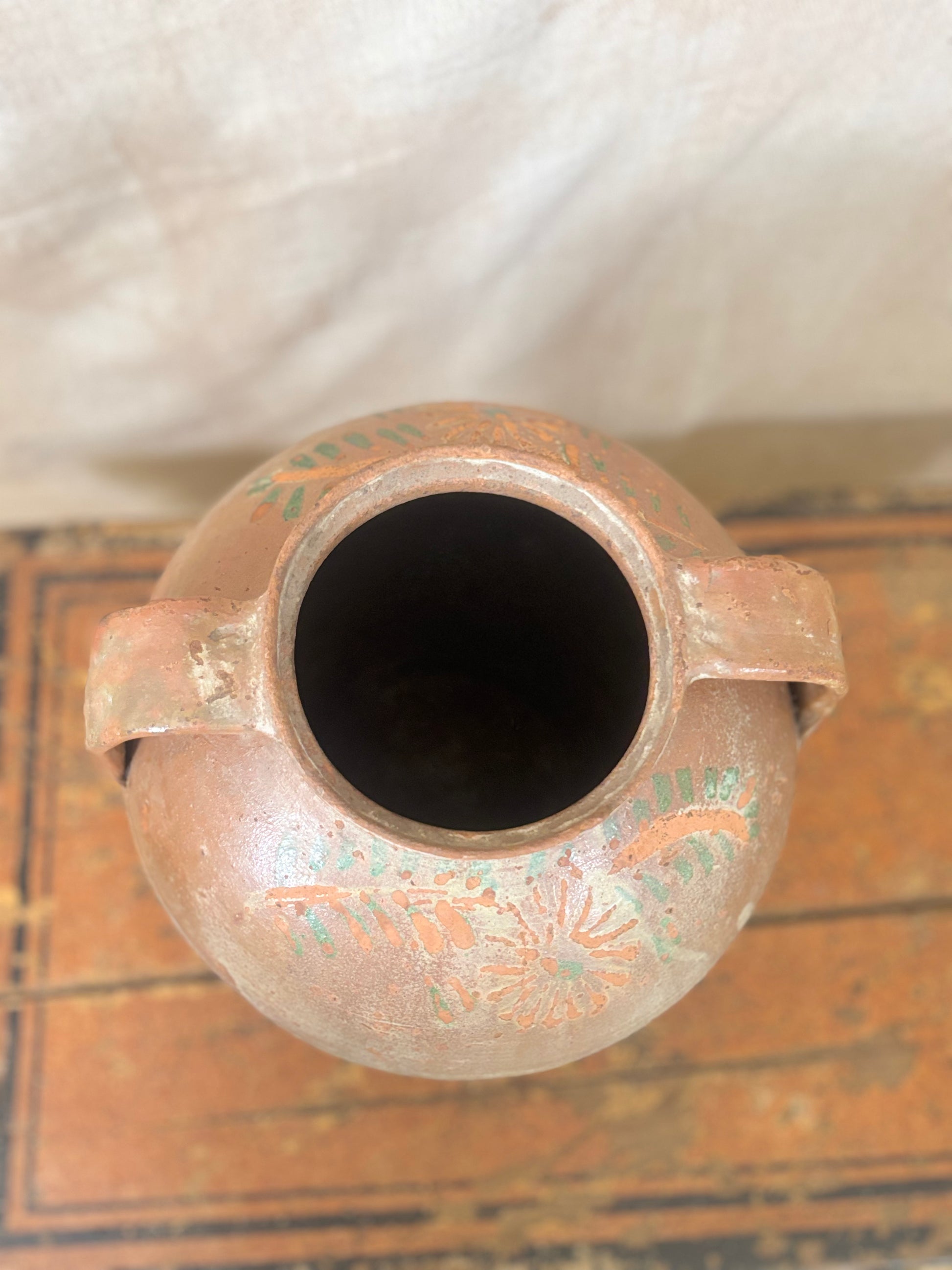 Ceramic vase with decorative patterns on a textured surface