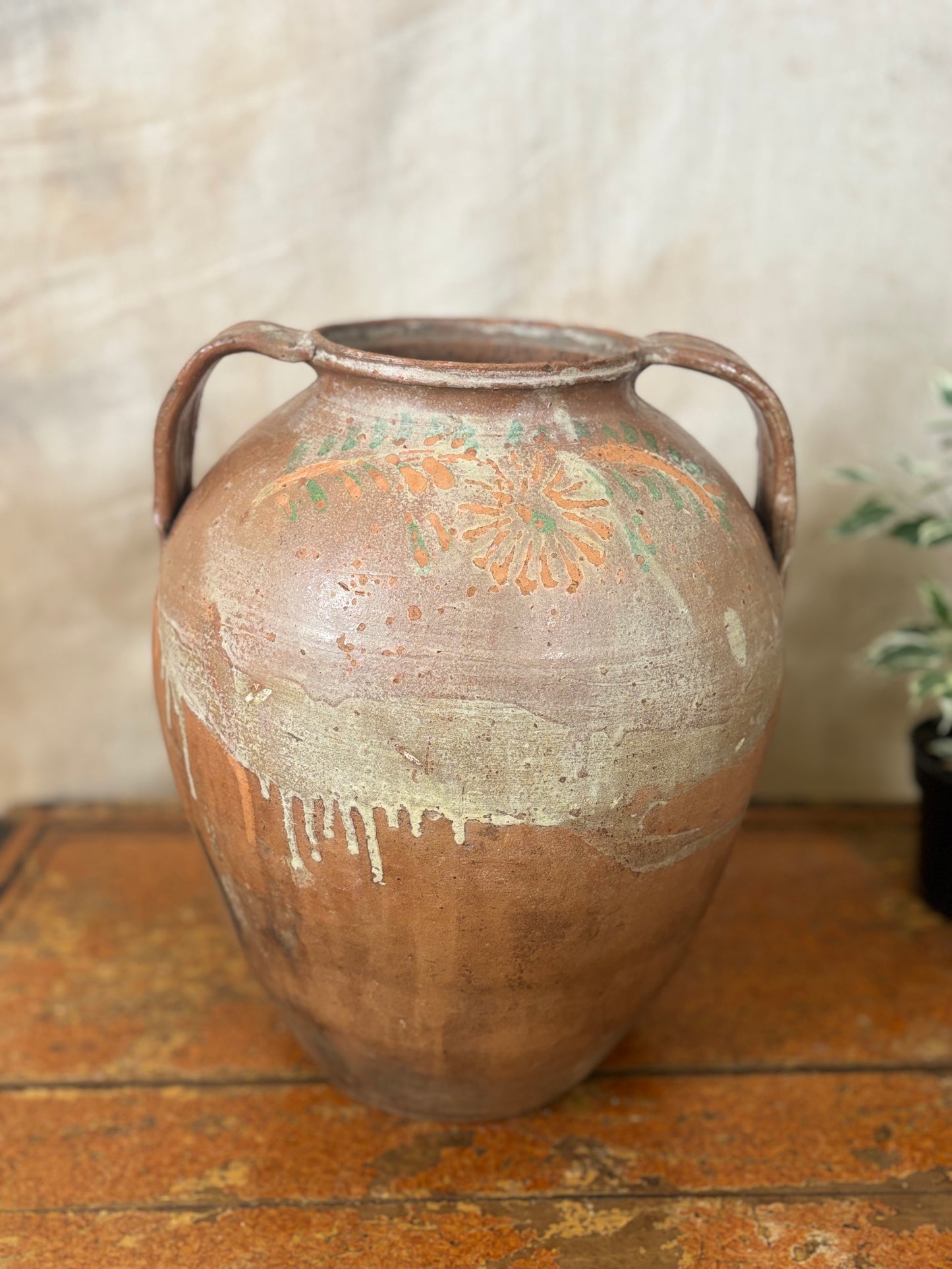 Vintage ceramic jar with handles on a wooden surface