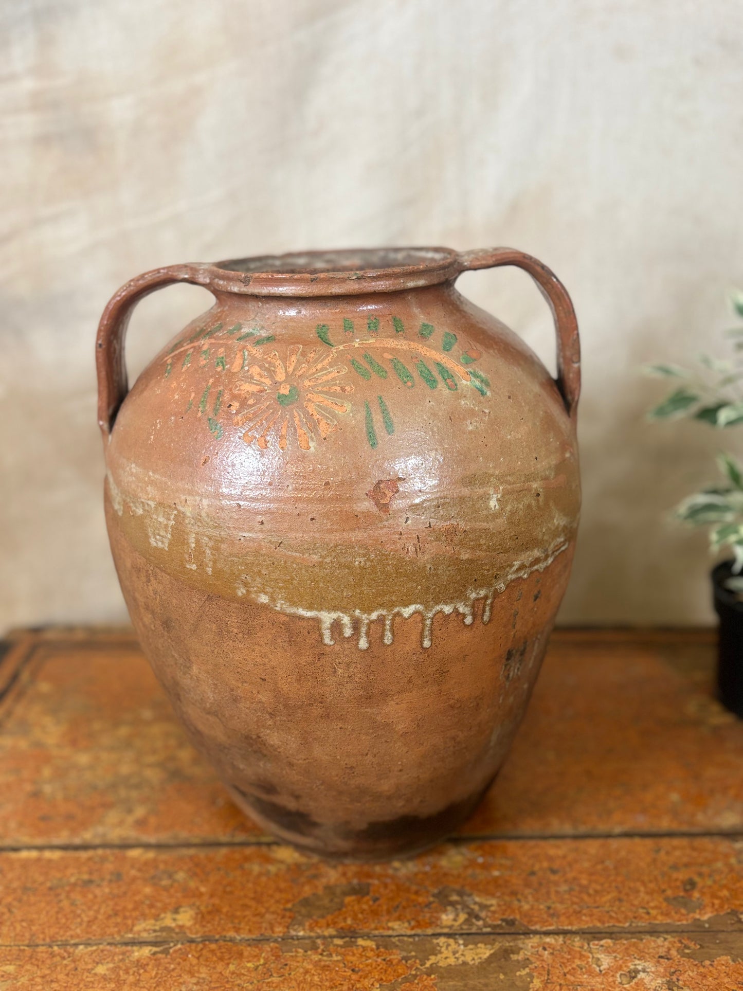 Vintage terracotta vase with handles on a wooden surface