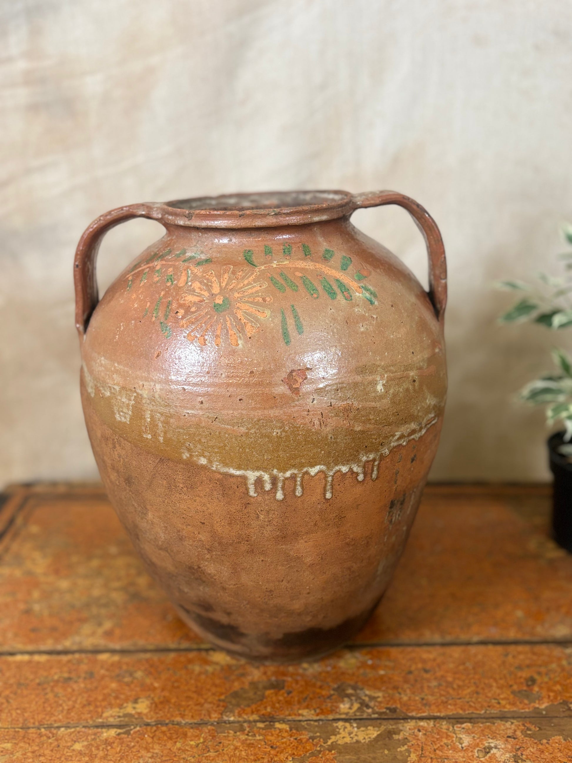 Vintage terracotta vase with handles on a wooden surface