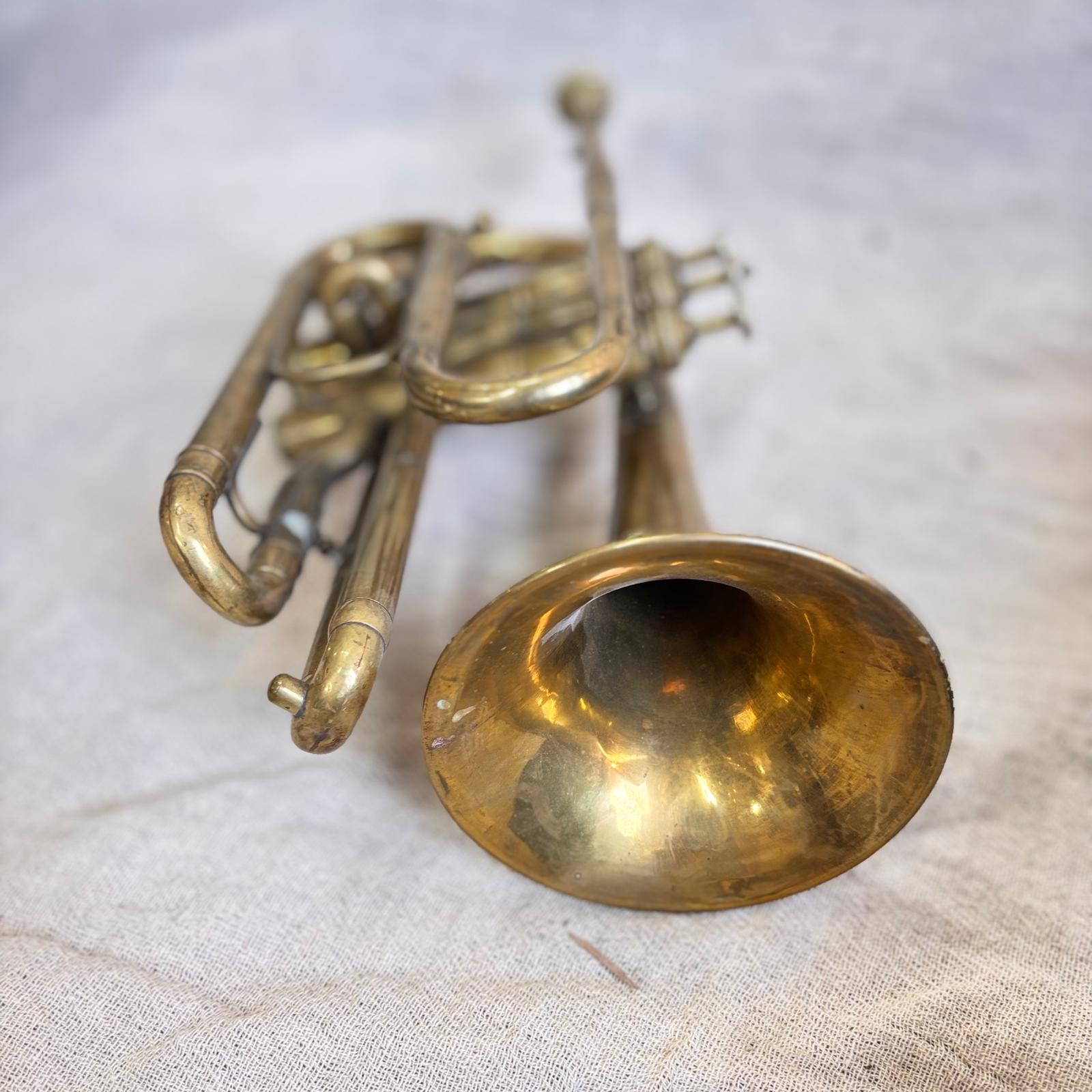 Vintage brass cornet on a textured fabric background
