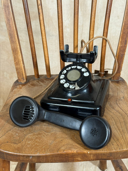 Vintage black rotary phone on a wooden surface
