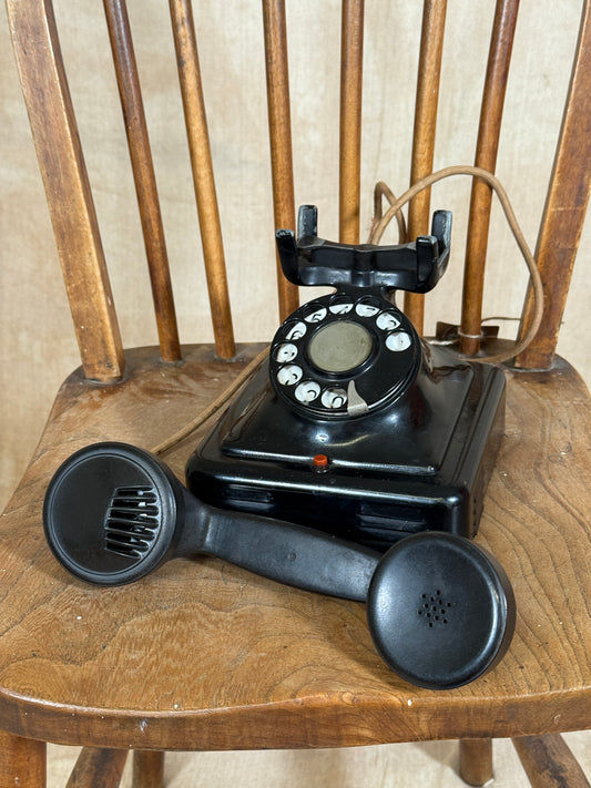 Vintage black rotary phone on a wooden surface