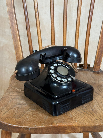 Vintage black rotary phone on a wooden surface