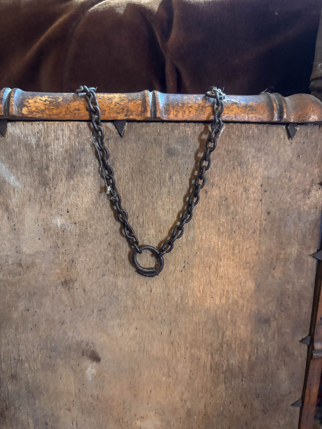 Chain attached to a wooden frame with a rustic background