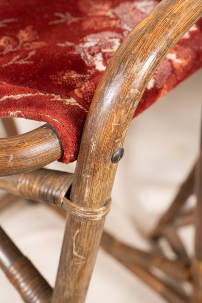 Pair of vintage bamboo bar stools with dark finished frames, red patterned velvet-style upholstery, X-shaped cross supports and lower footrests.