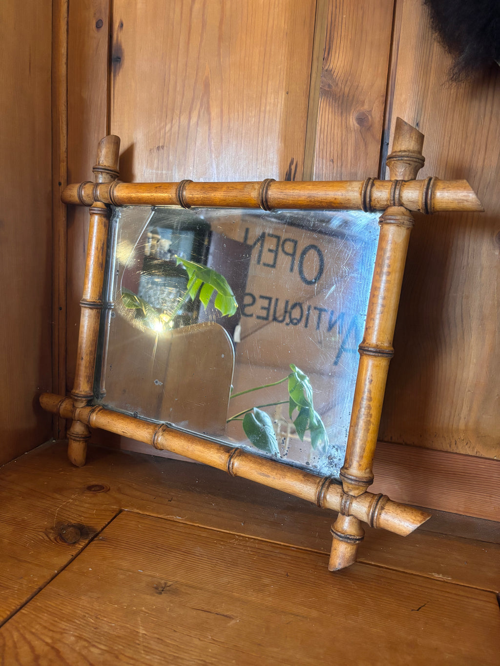 Wooden mirror with bamboo-style frame on a wooden surface