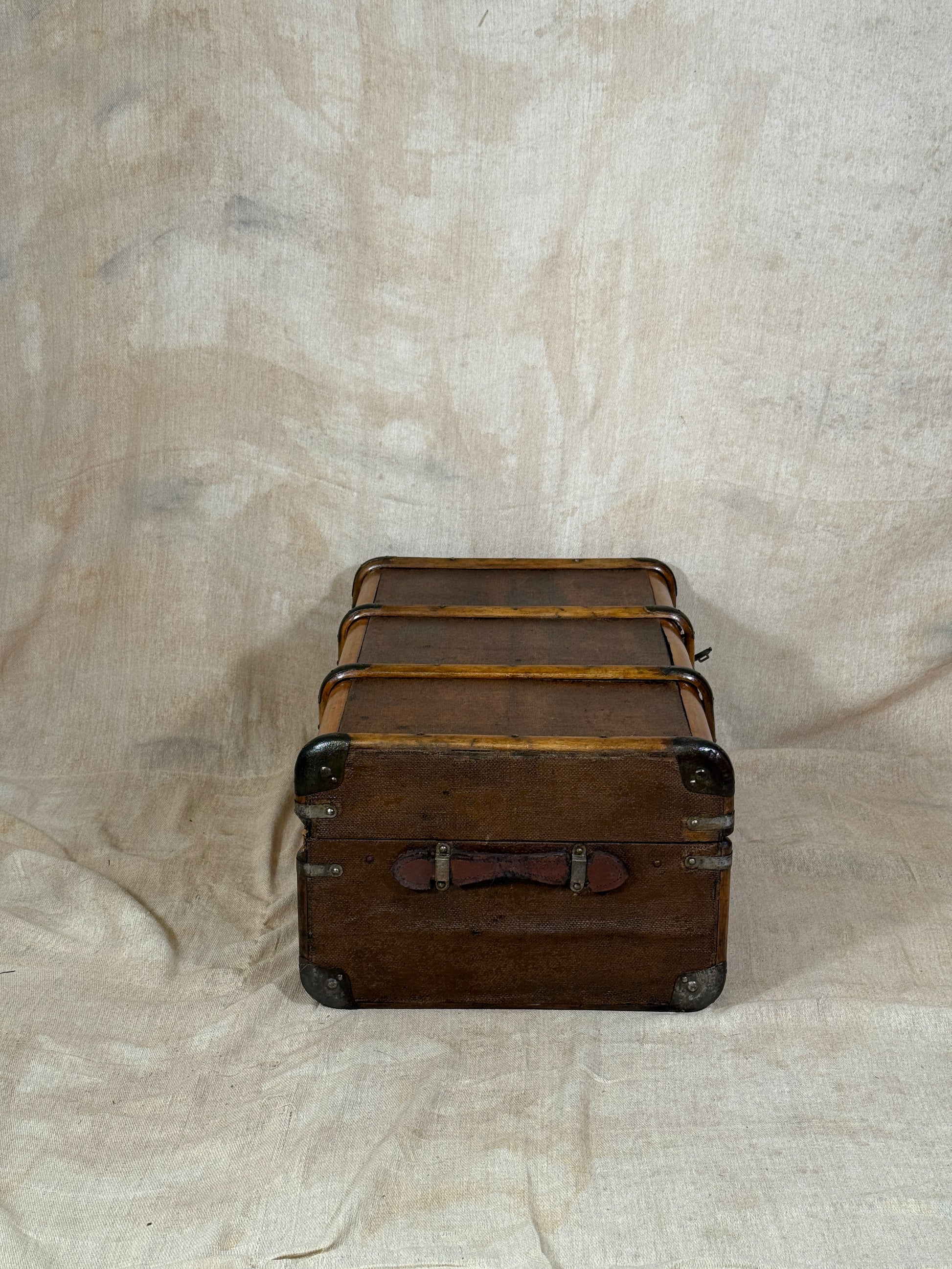 Vintage leather suitcase on a textured beige surface