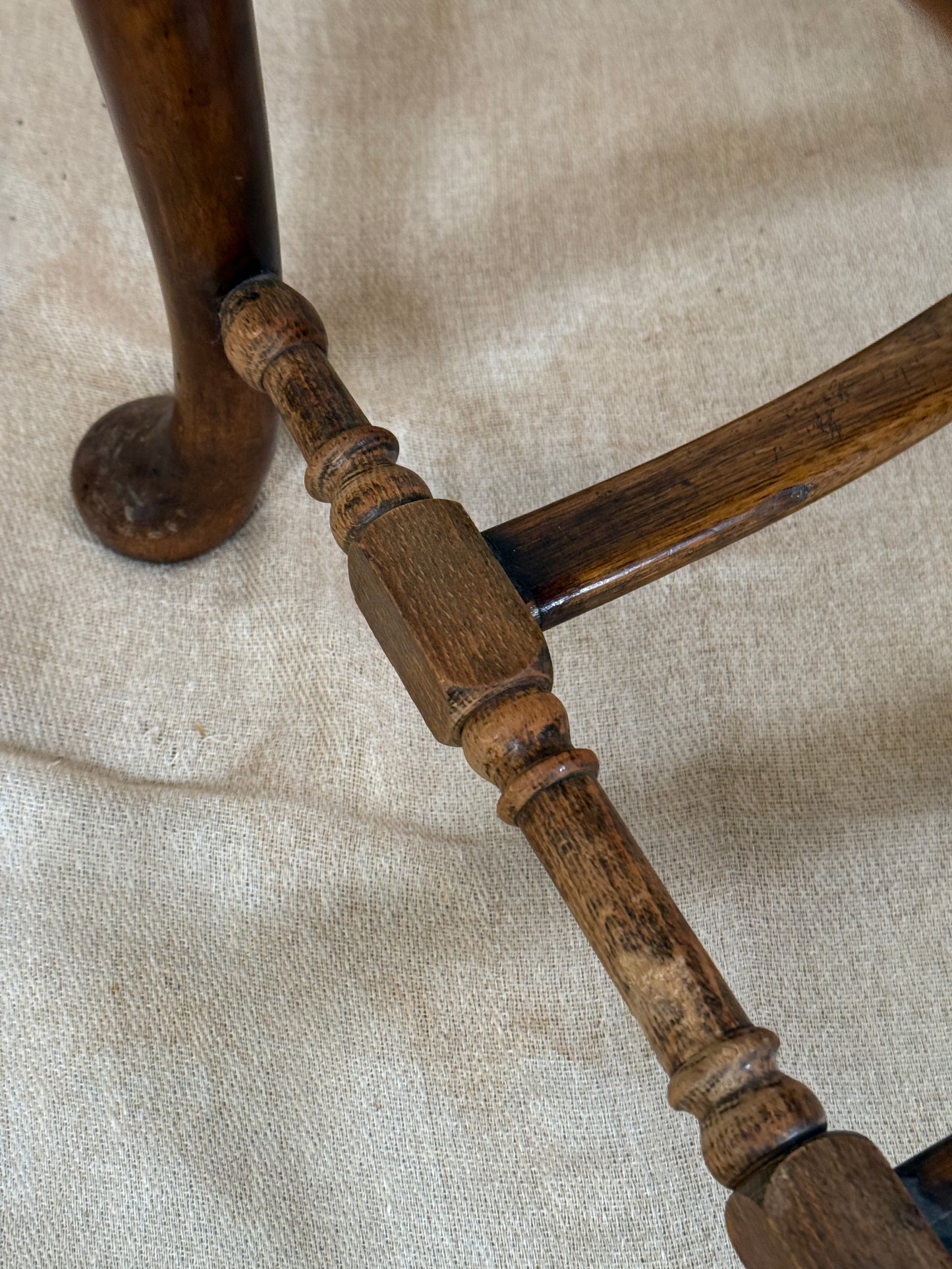 Antique Bergère style cane armchair and matching footstool with dark carved wooden frames and woven cane panels.