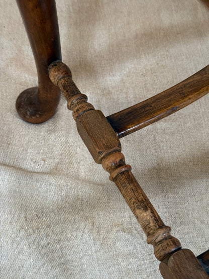 Antique Bergère style cane armchair and matching footstool with dark carved wooden frames and woven cane panels.