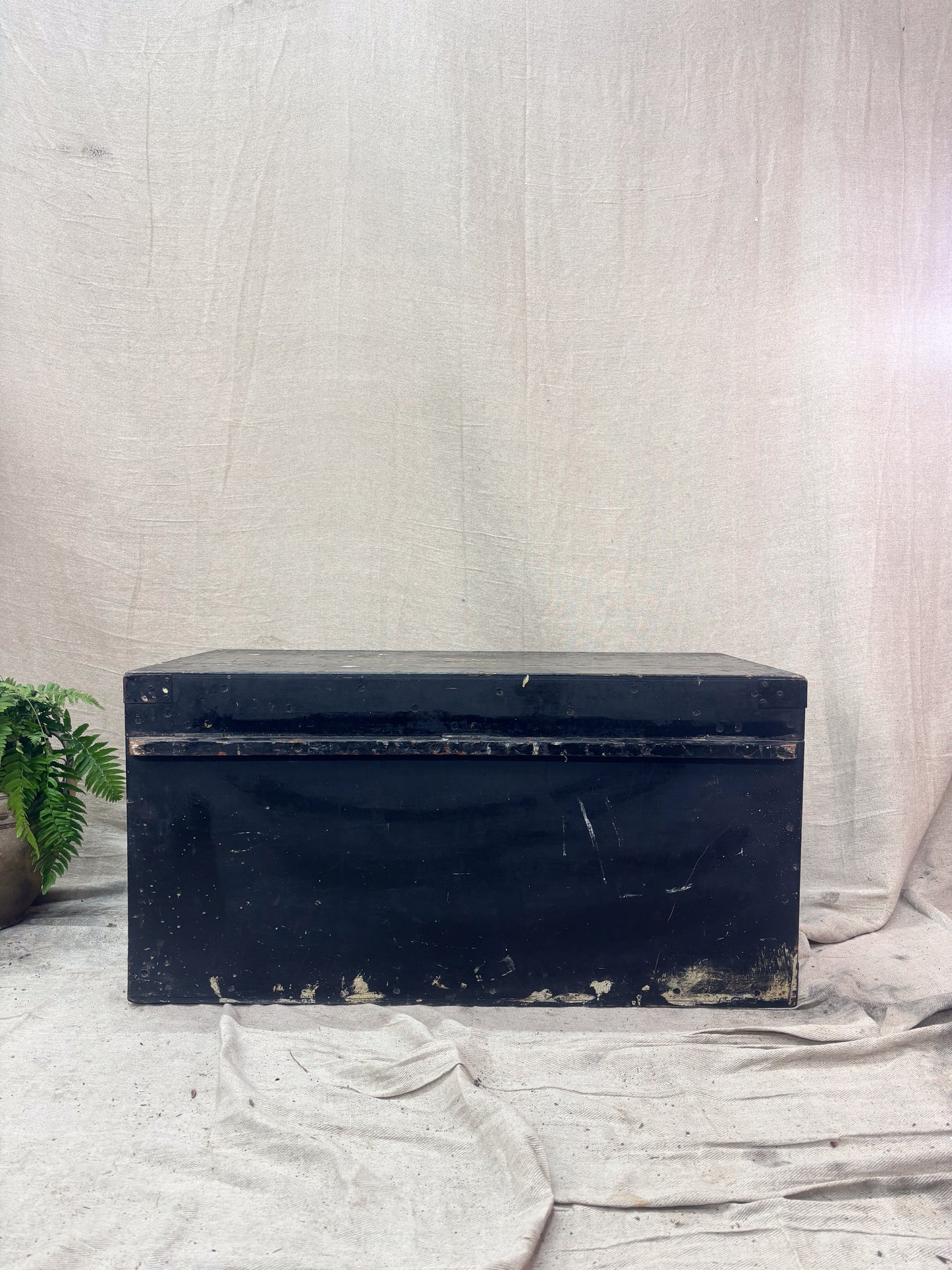 Black rectangular box on a textured white surface with a light gray background