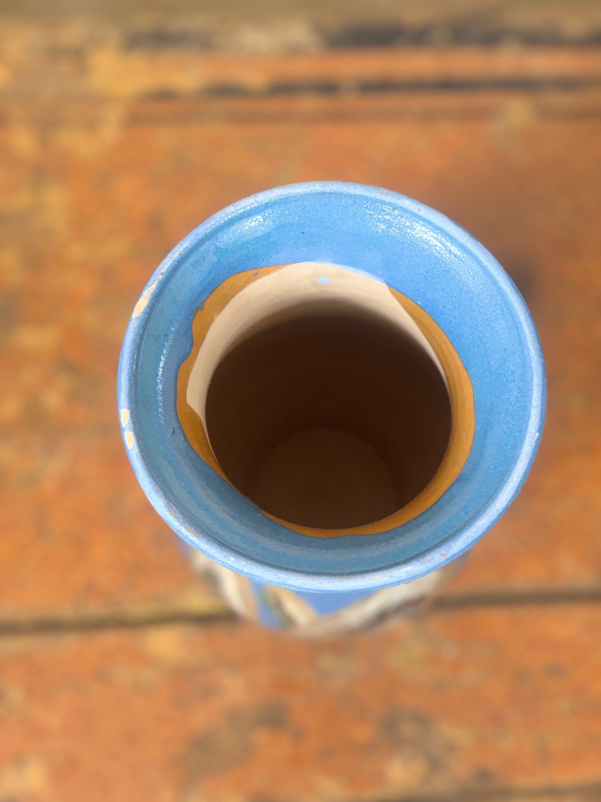 Close-up of a blue ceramic vase on a wooden surface