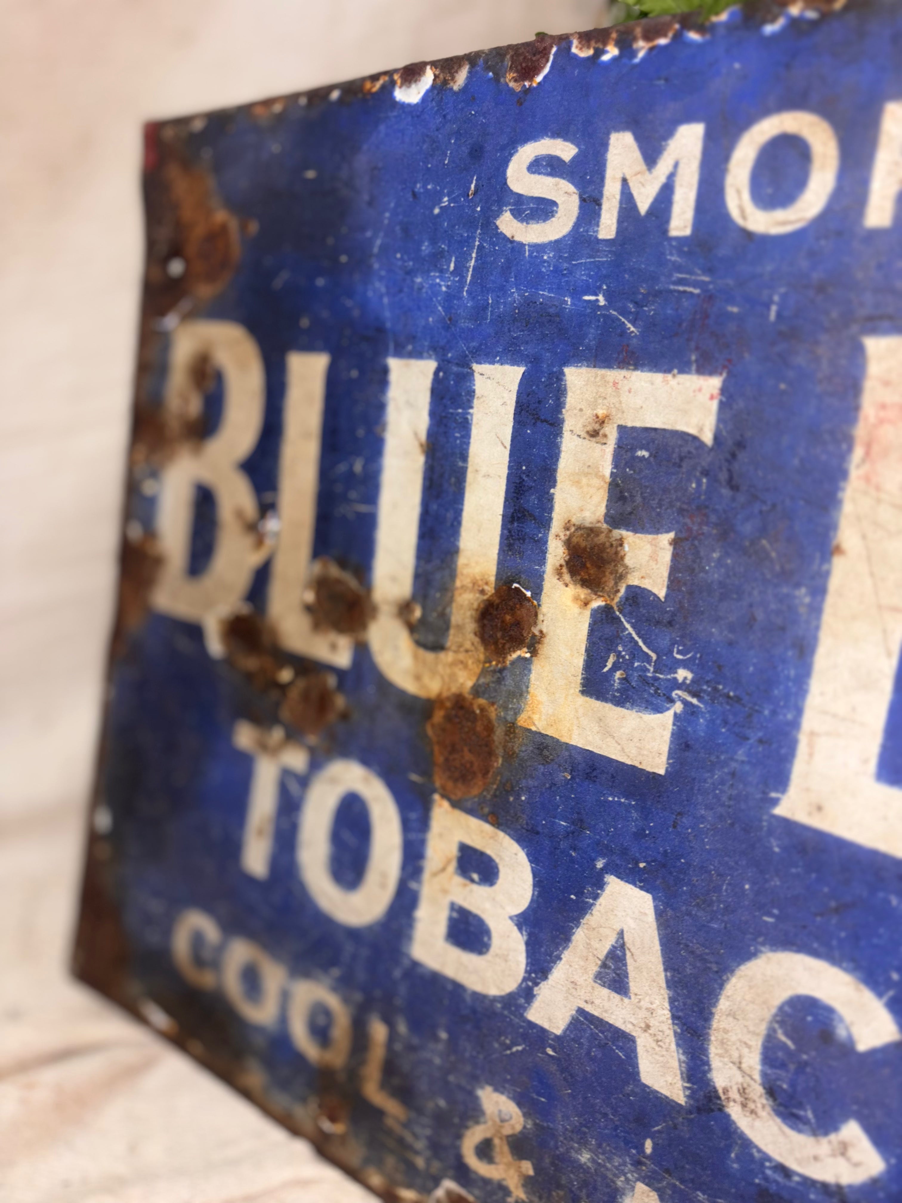 Rustic blue sign with white text on a textured surface