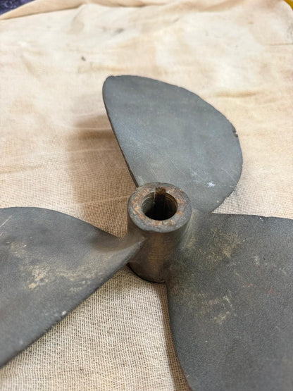 Vintage three-blade metal propeller on a burlap background