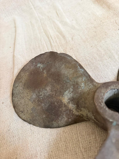 Bronze axe head on a beige fabric background