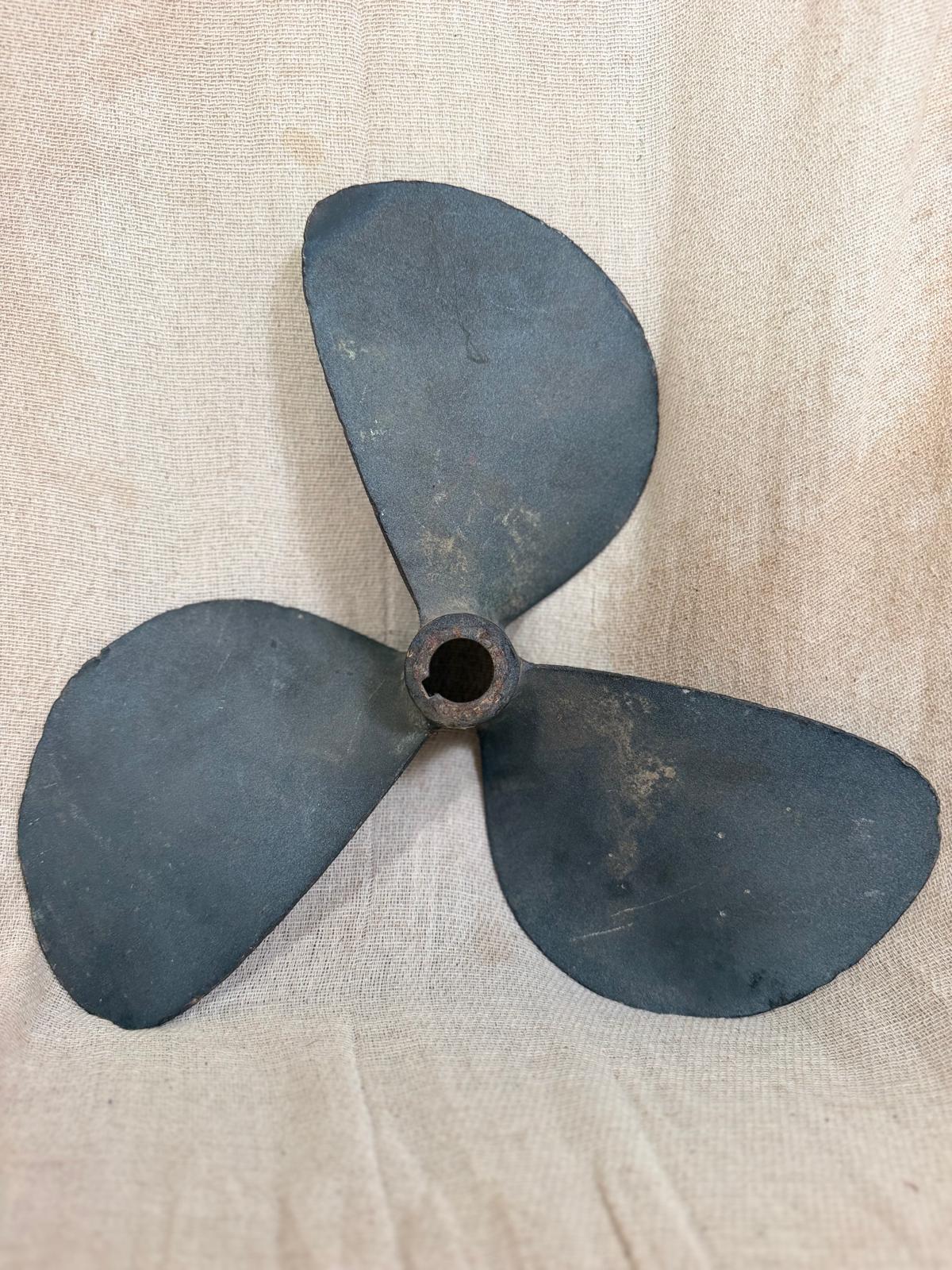 Vintage three-blade propeller on a beige fabric background
