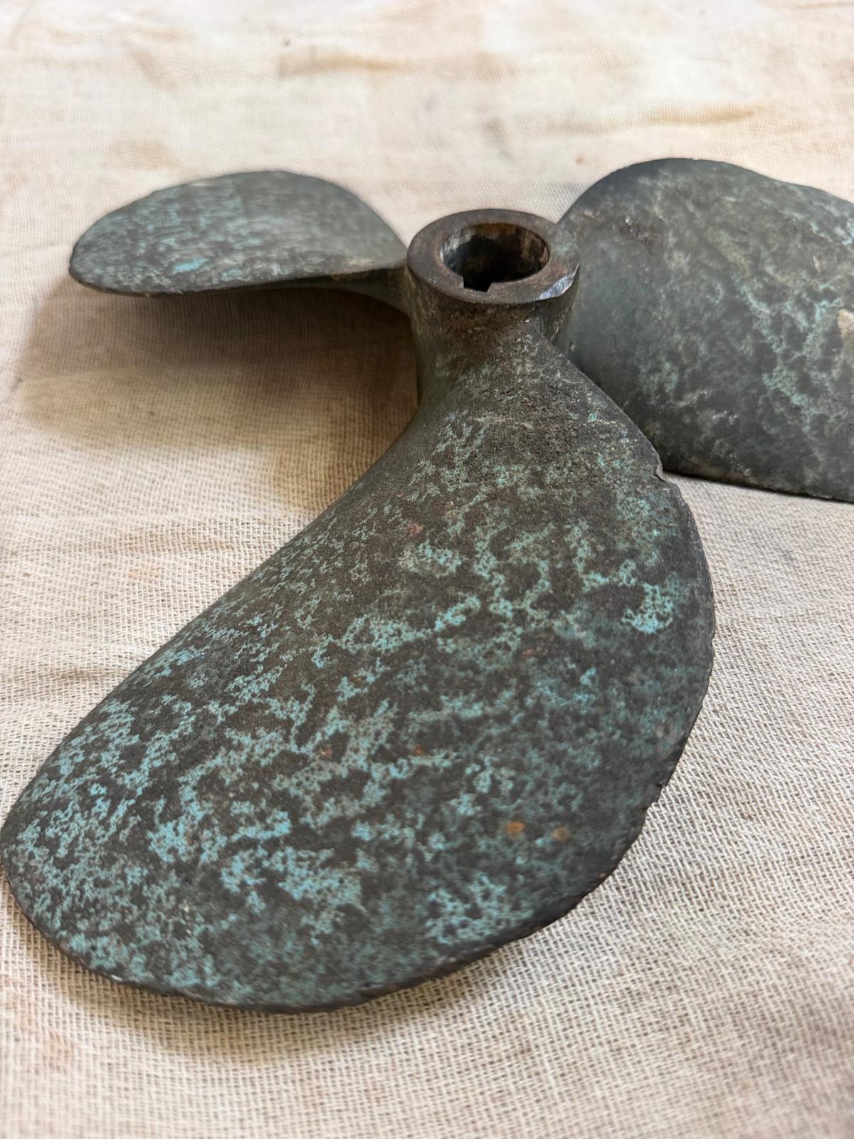 Vintage metal propeller on a textured beige background