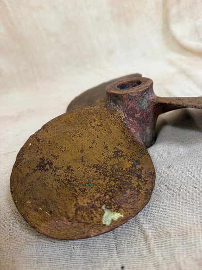 Rust-covered metal object on a textured beige background