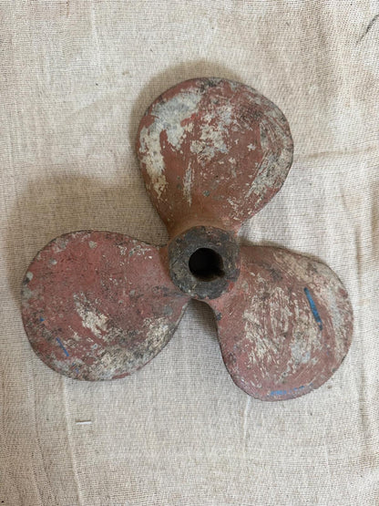 Rust-colored propeller on a textured beige background