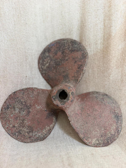Rust-colored propeller on a textured beige background