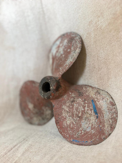 Rust-colored propeller on a beige fabric background