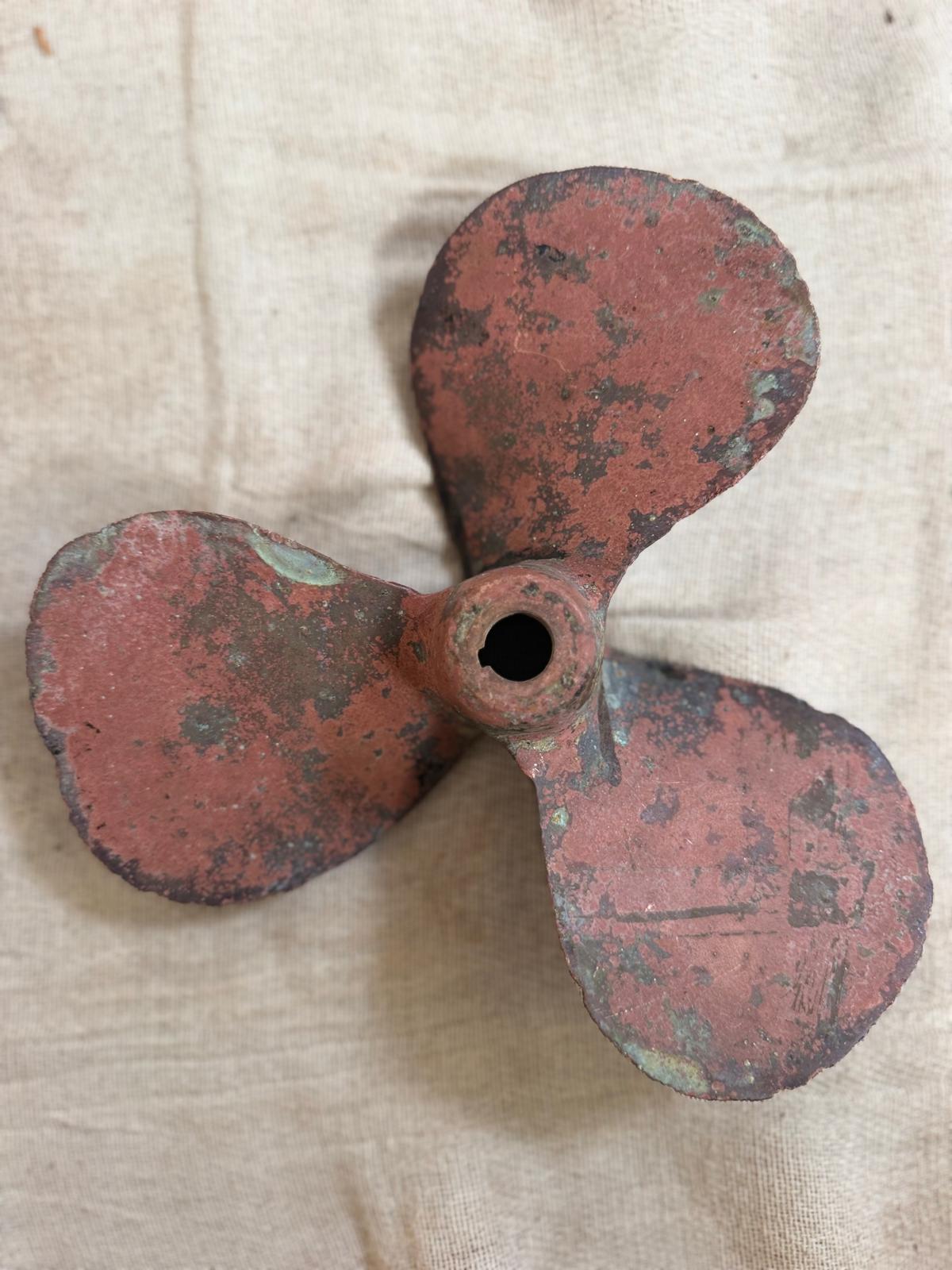 Rust-colored propeller on a beige fabric background
