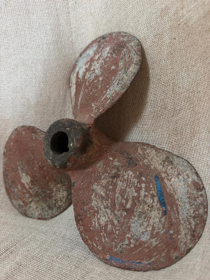 Rust-colored propeller on a textured beige background