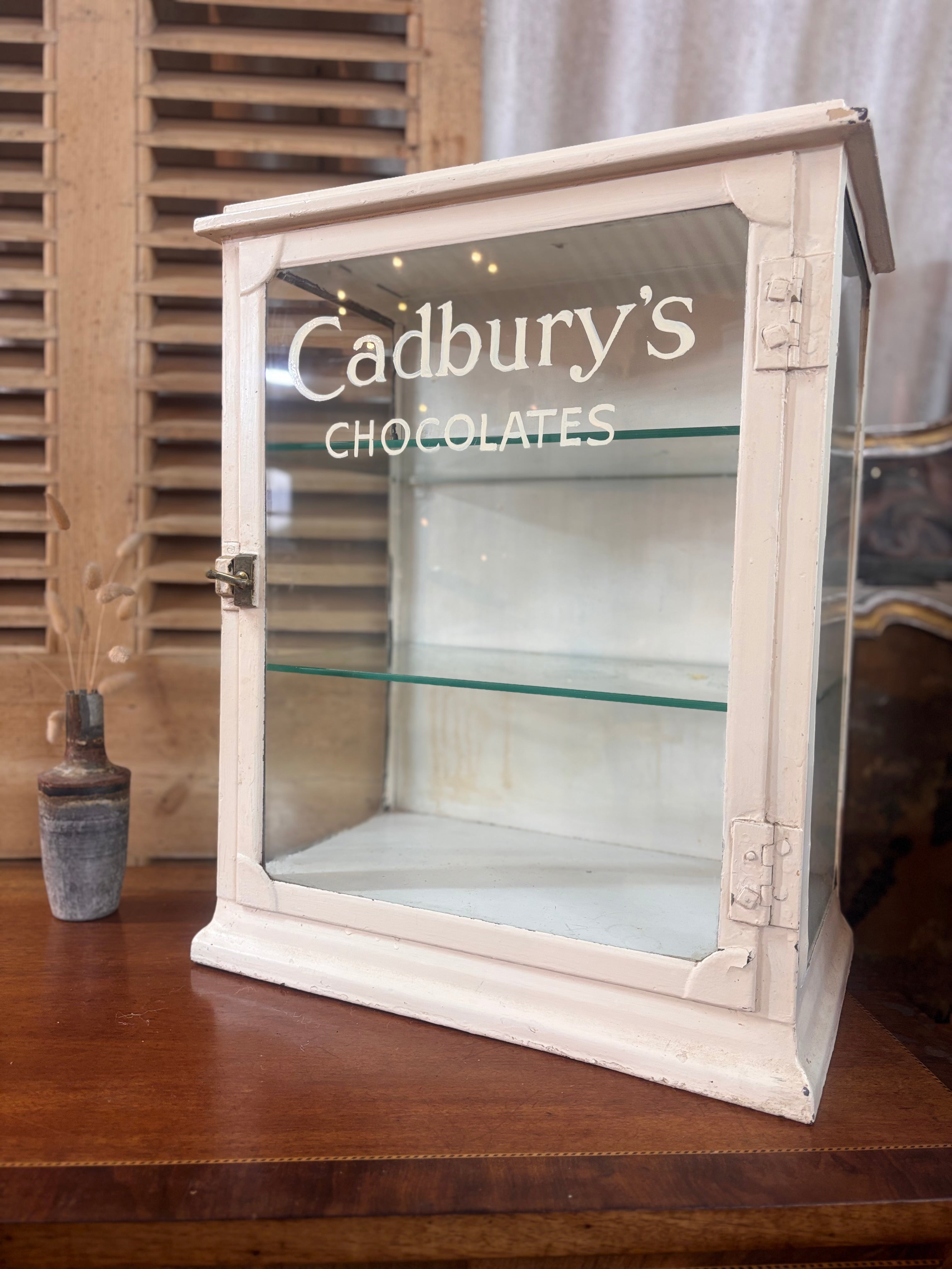 White painted metal Cadburys chocolate display cabinet with glass front, original lettering and aged patina.