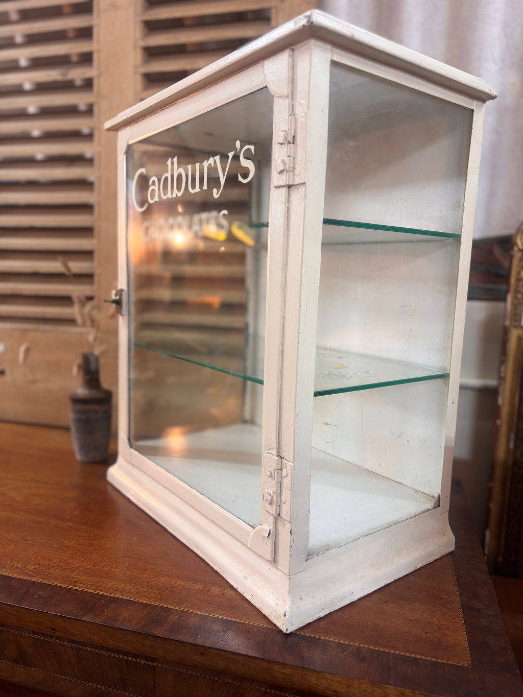 White painted metal Cadburys chocolate display cabinet with glass front, original lettering and aged patina.