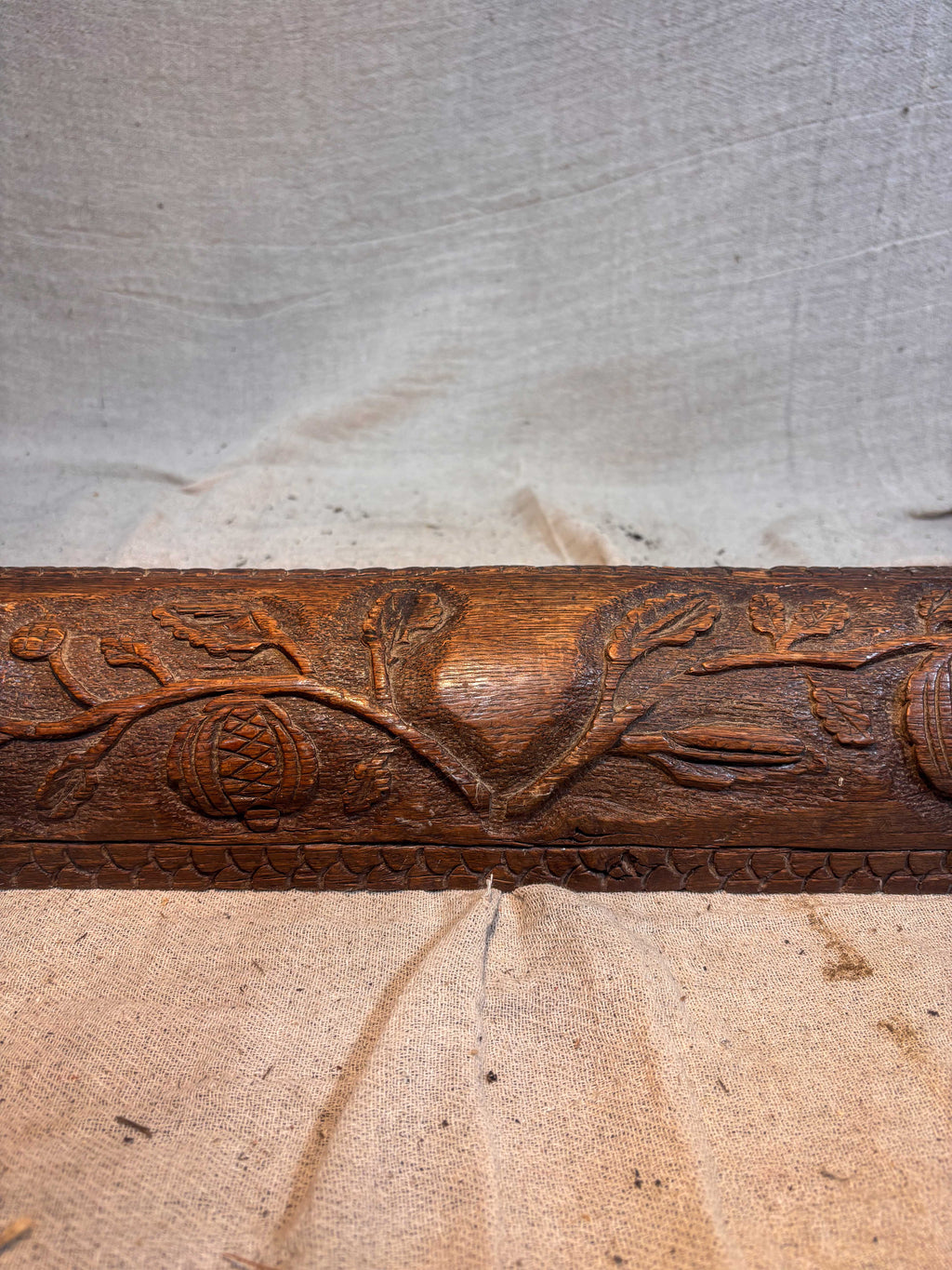 Wooden fire fender with floral design on a textured surface