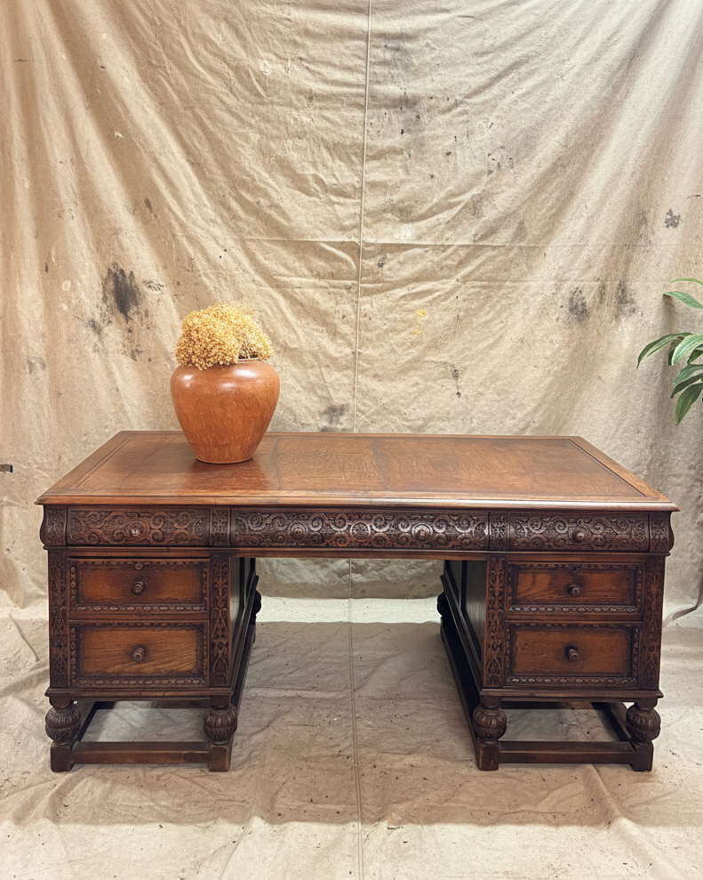 Wooden desk with a vase on top against a plain backdrop
