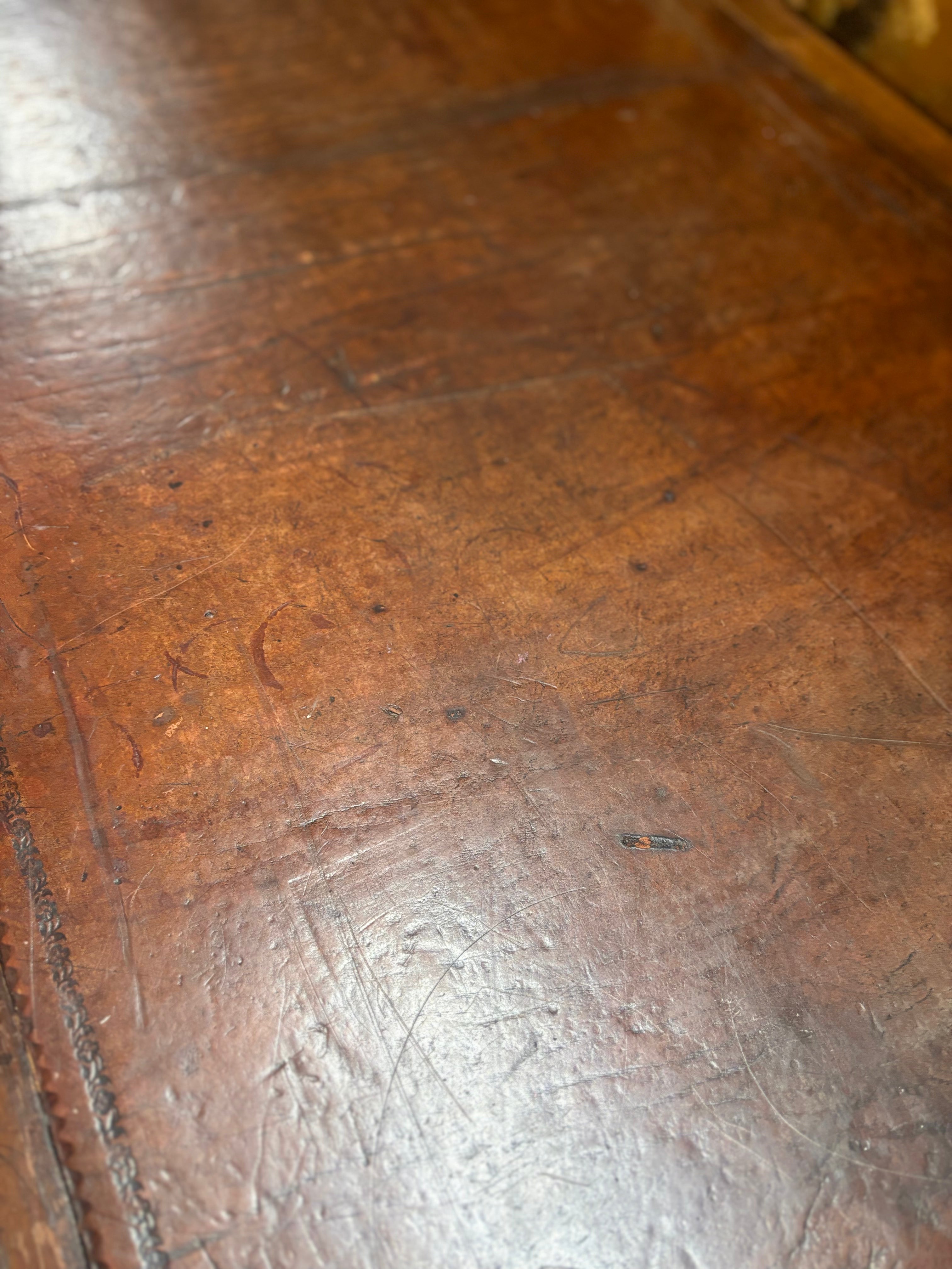 Close-up of a worn leather writing surface with visible grain and texture