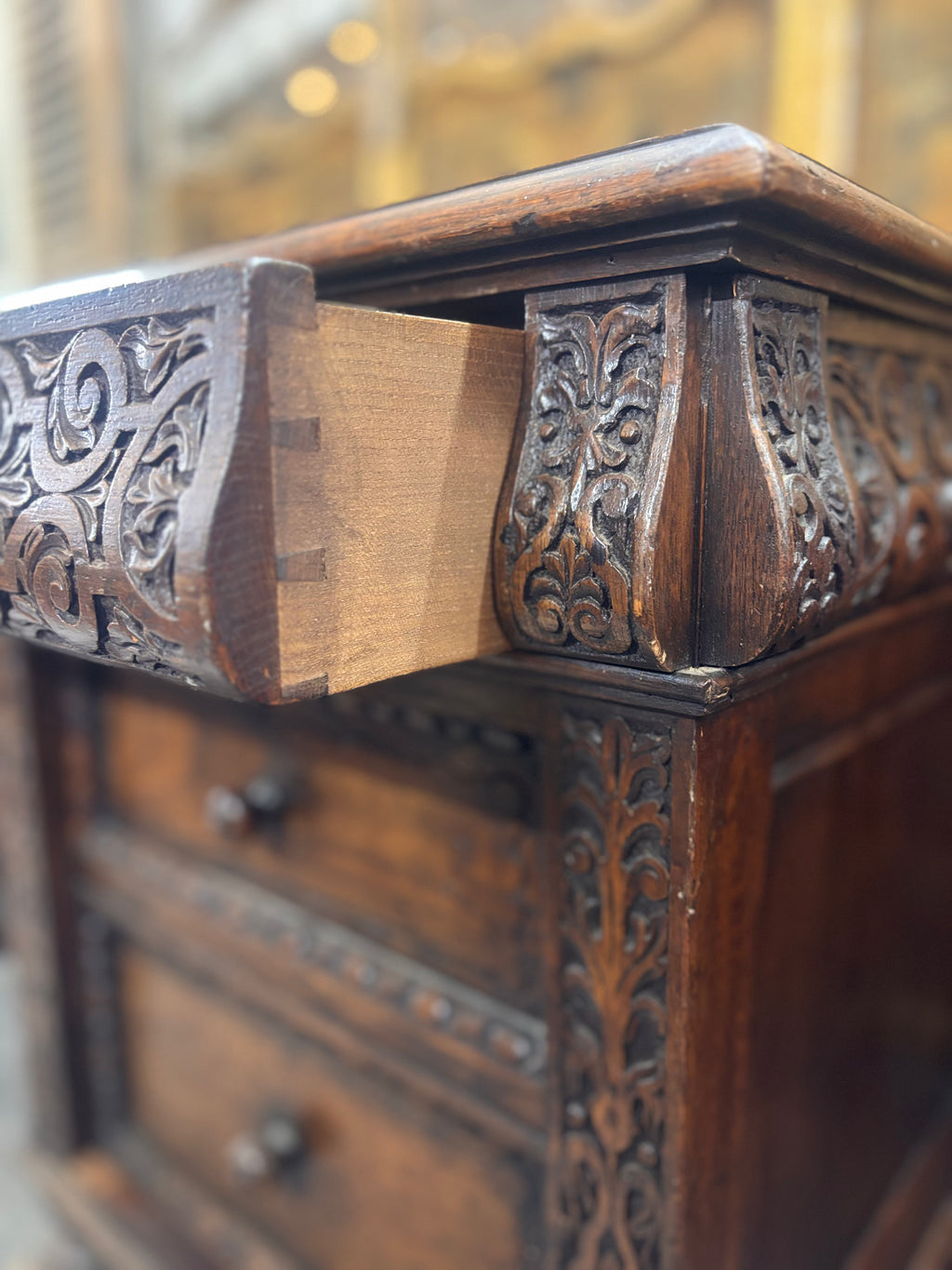 Close-up of an ornate wooden desk with intricate carvings.