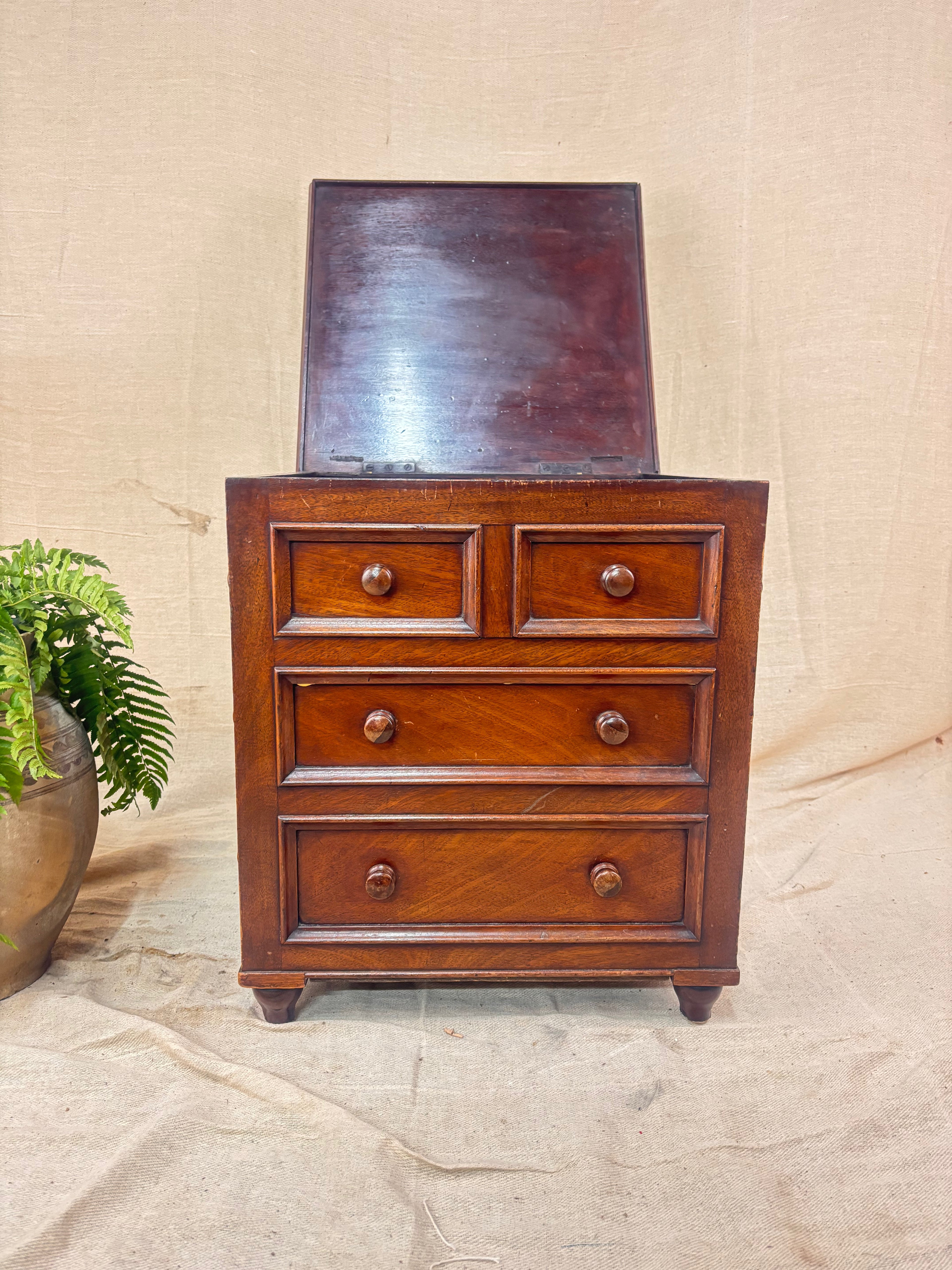 Wooden dresser with four drawers on a textured beige background