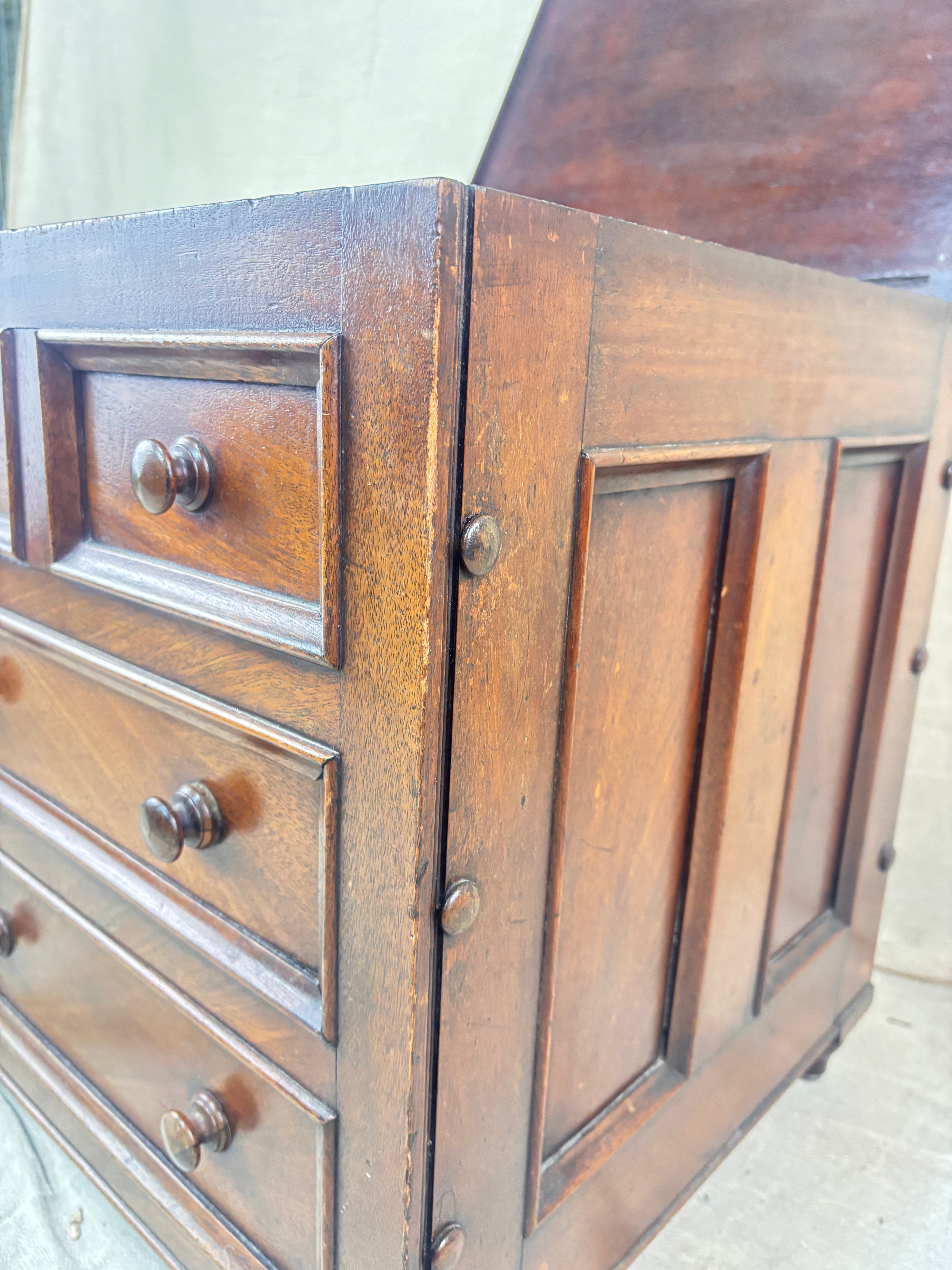 Close-up of a wooden dresser with drawers and panel design.