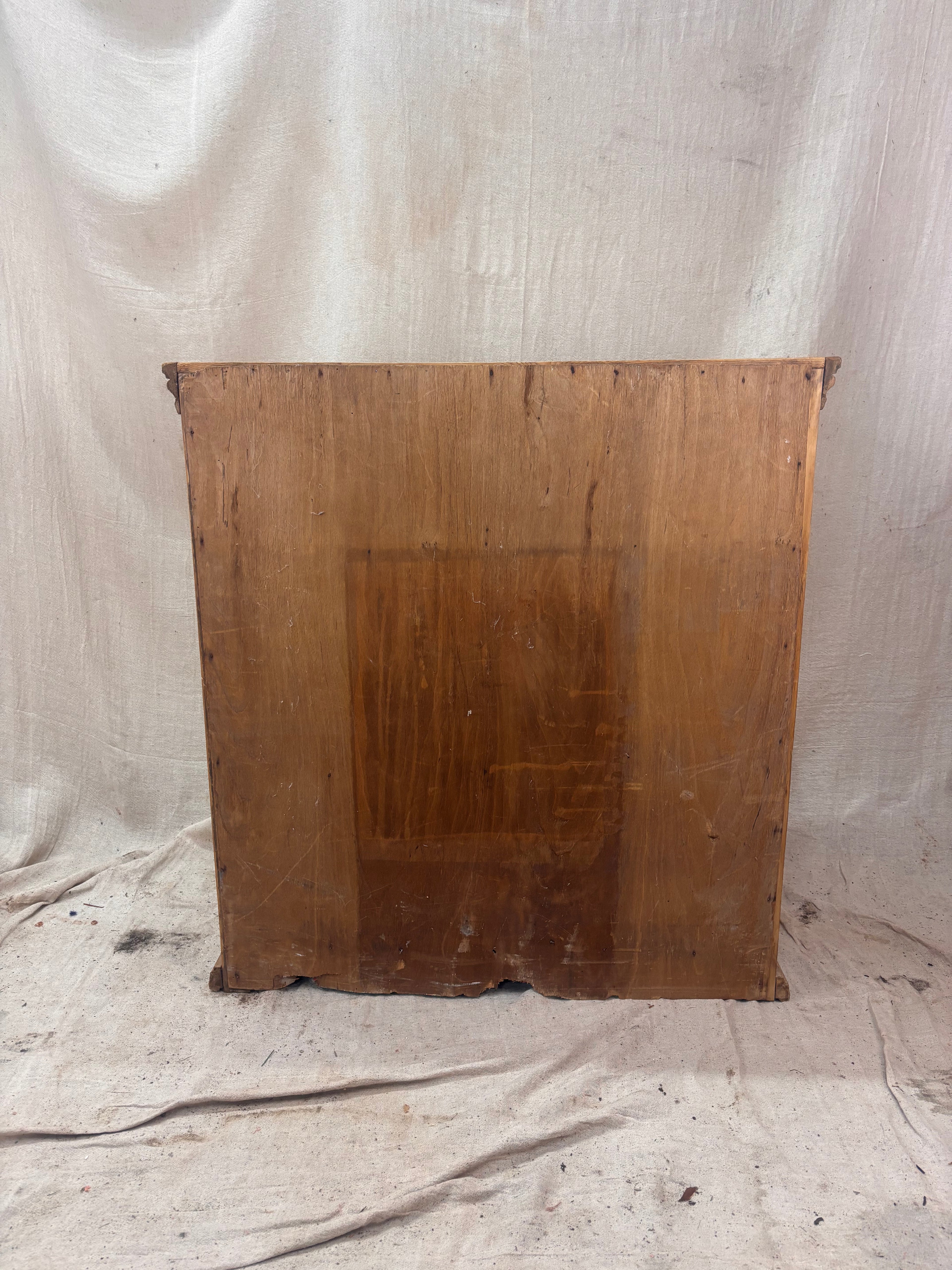 Back of a pine chest of drawers on a white fabric background