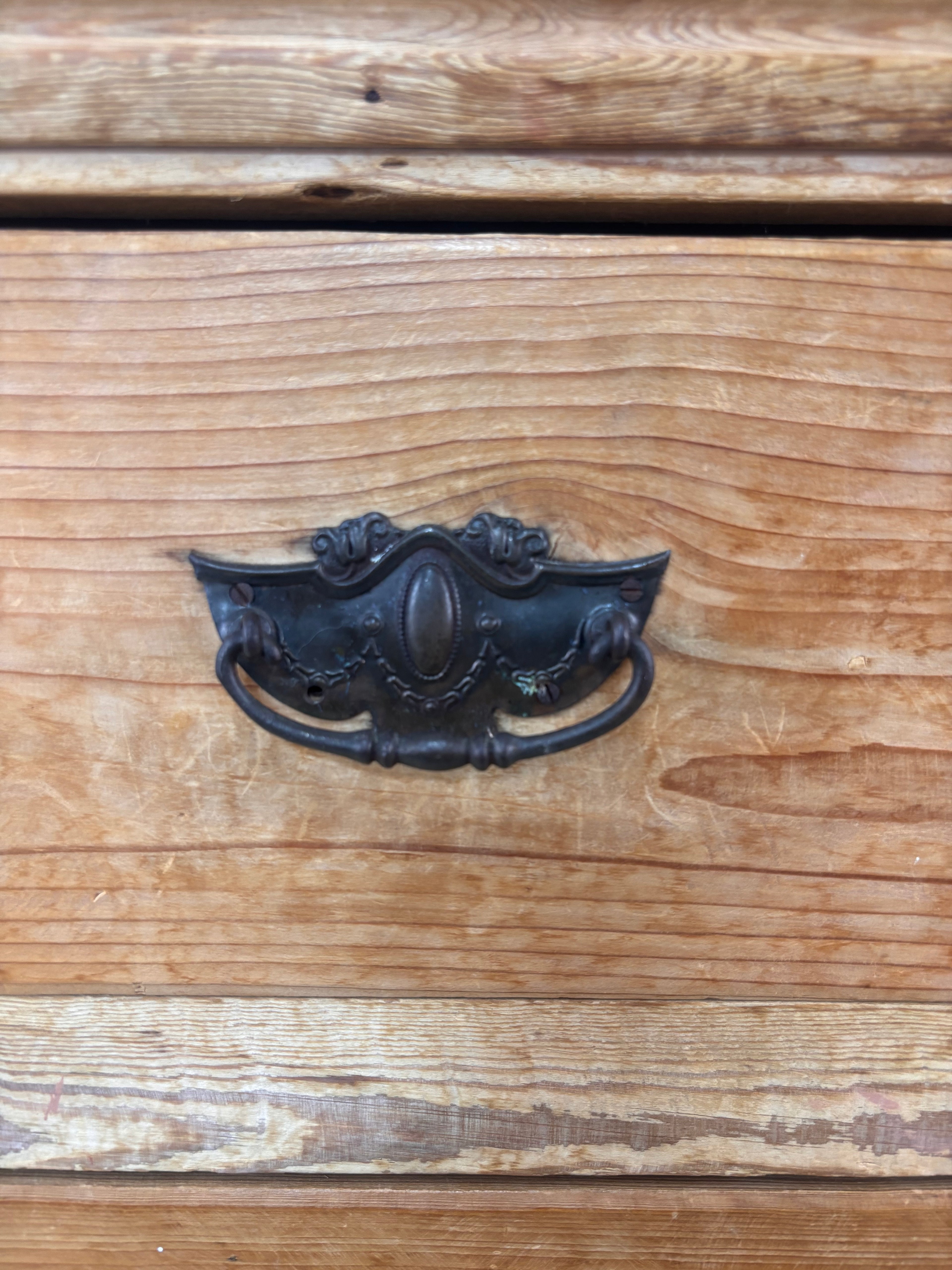 Decorative metal handle on a wooden drawer