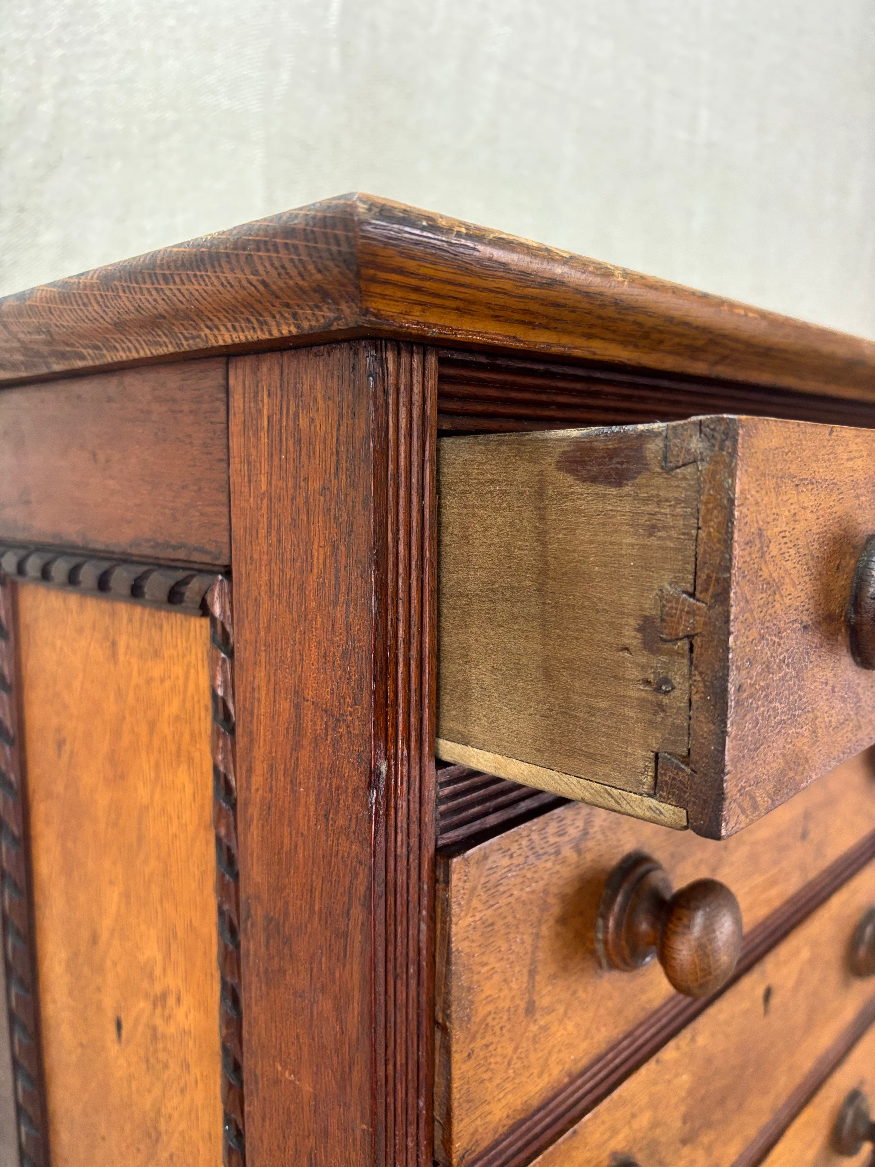 Close-up of an old wooden cabinet with a drawer open, showing worn wood and metal handles.